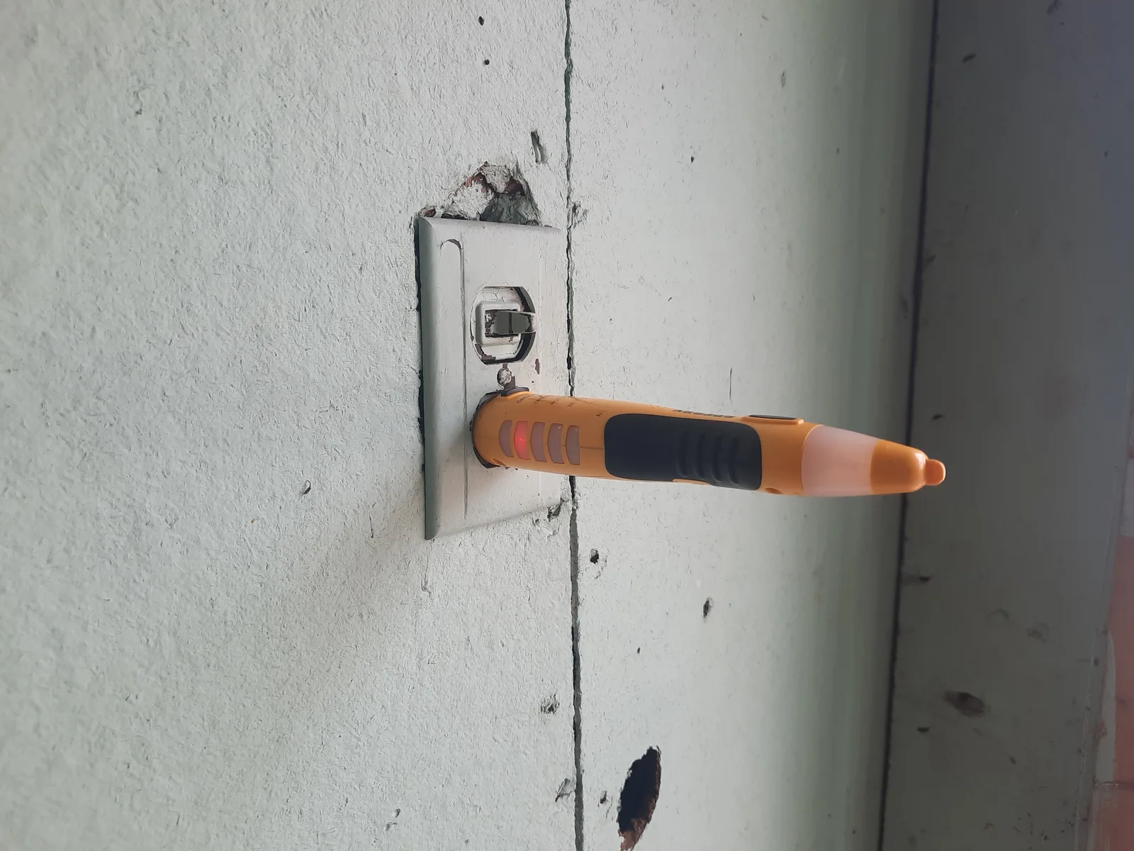 Electrical receptacle checked with a voltage tester during a building review