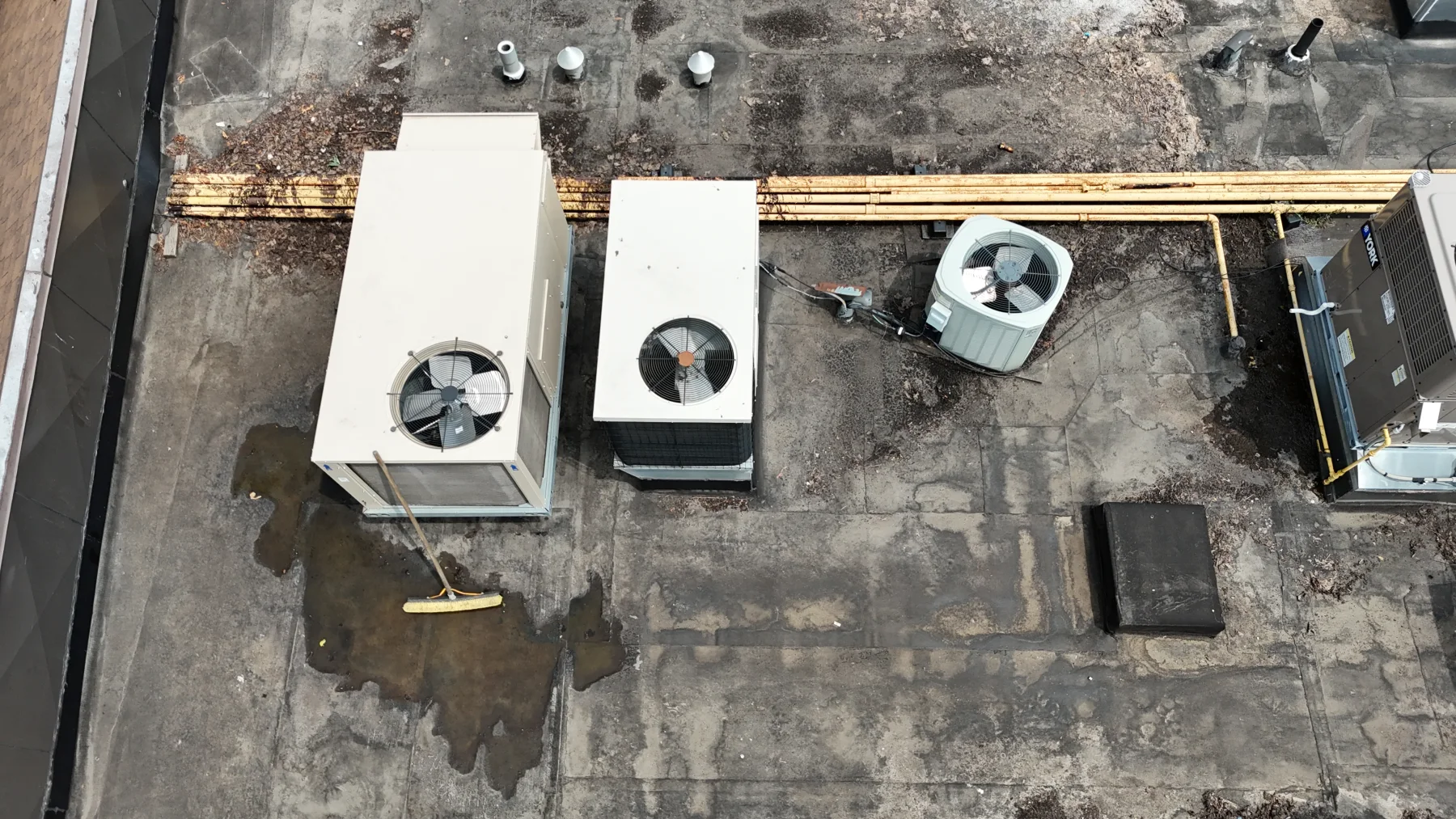Rooftop heating and cooling equipment with gas distribution visible across a commercial roof