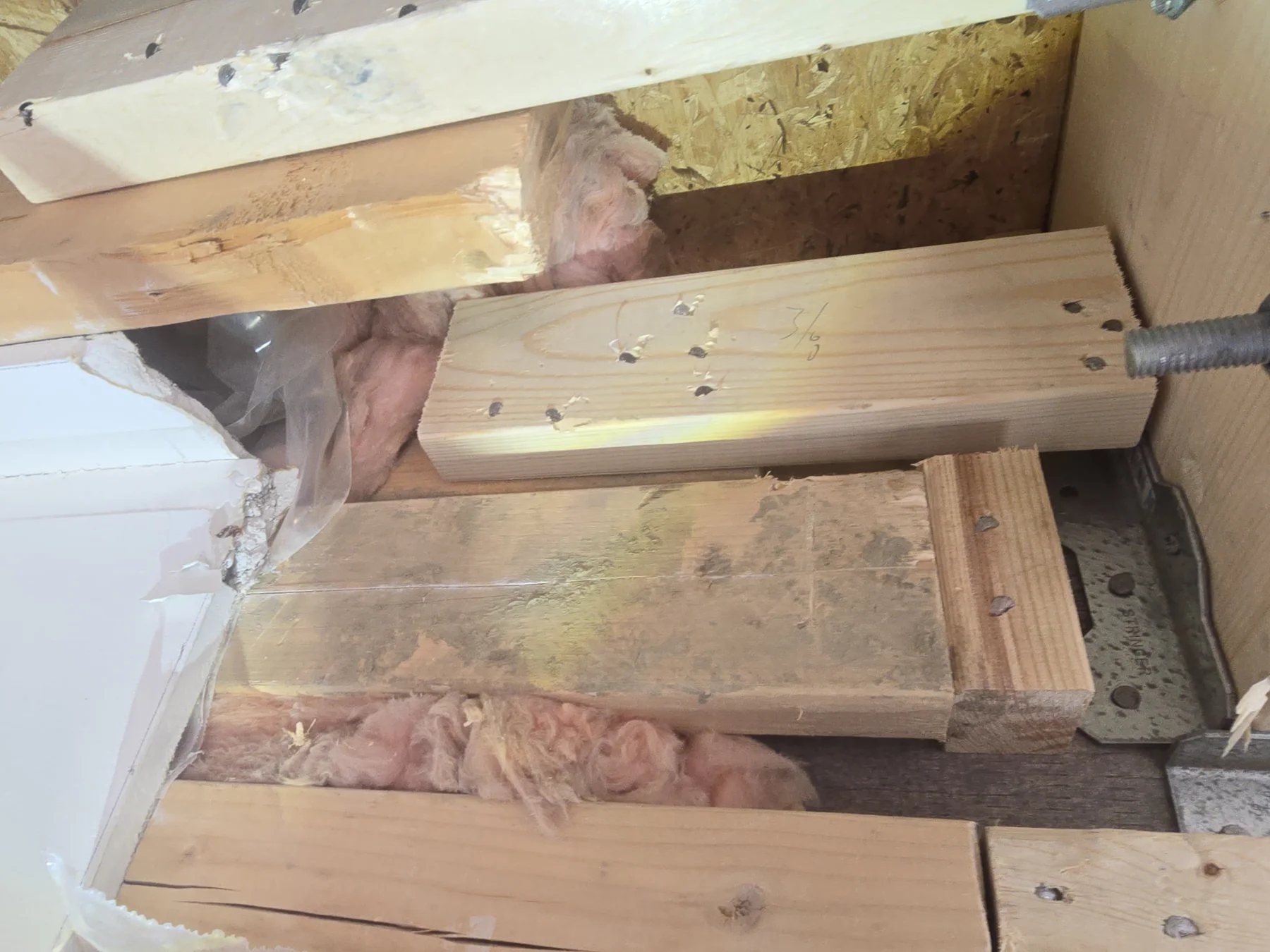 Bolted timber reinforcement and connection hardware inside an opened wall